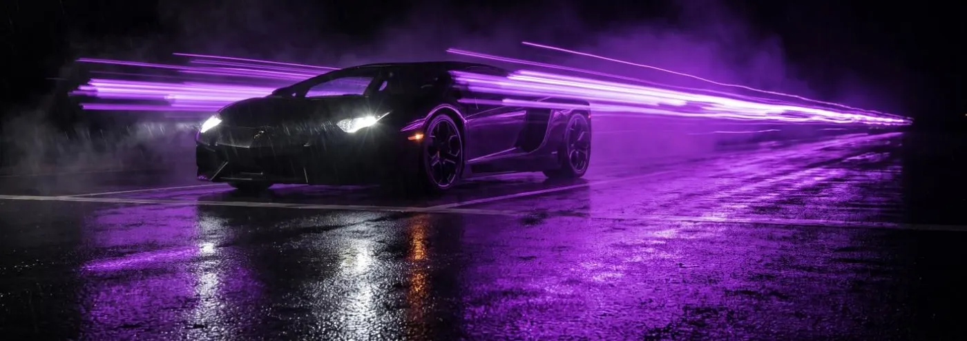 Černé sportovní auto na startu s fialovými světelnými stopami
